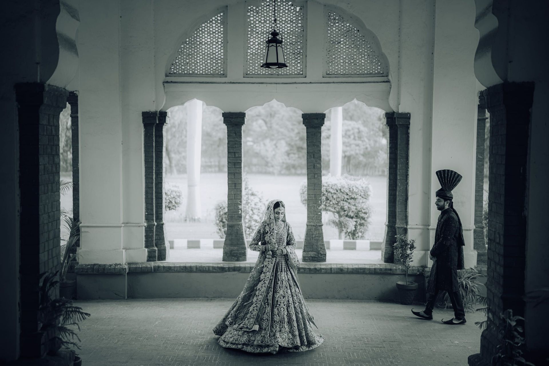 Bride in a heritage hall of arches and stone columns during a Lahore wedding shoot